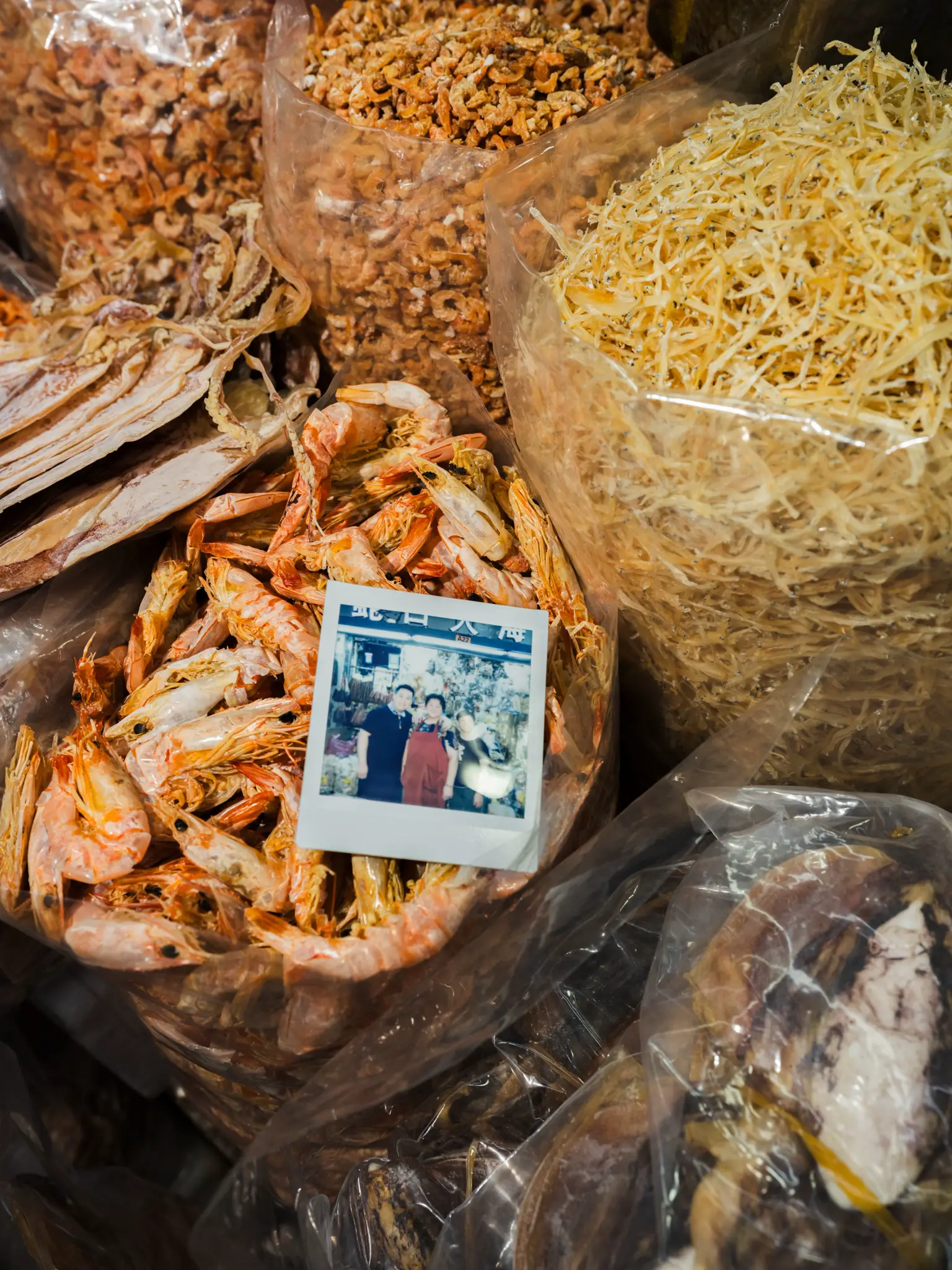 Dried seafood at a market with an instant photograph of the vendors